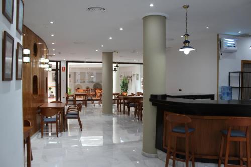カスティジェハ・デ・ラ・クエスタにあるHOTEL HACIENDA SANTA BARBARAのテーブルと椅子のあるレストラン、バー