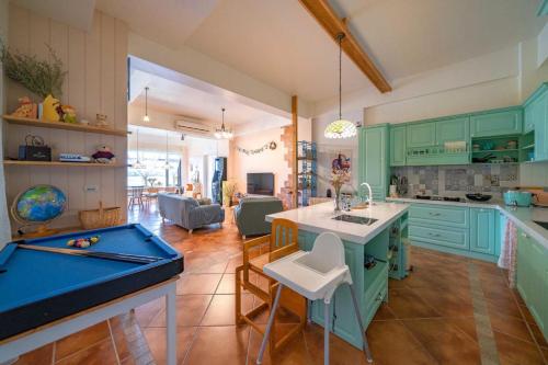a kitchen with blue cabinets and a pool table at Cathy French House in Dongshan