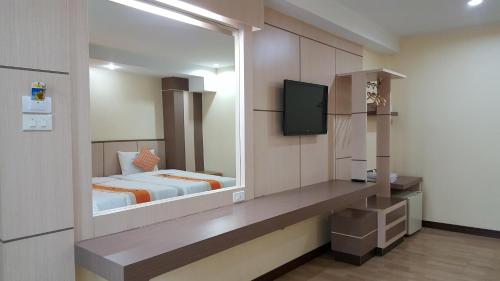 a bedroom with a bed and a television in it at Kaen Nakorn Hotel in Khon Kaen