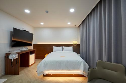 a bedroom with a bed and a flat screen tv at Hotel sounds in Jeonju
