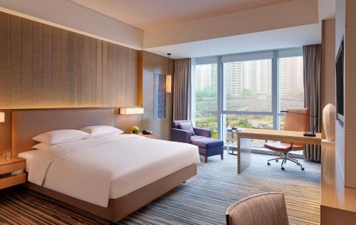 Hyatt Regency Chongqing Hotel في تشونغتشينغ: غرفة في الفندق مع سرير ومكتب