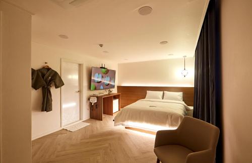 1 dormitorio con 1 cama y 1 silla en Hotel sounds, en Jeonju