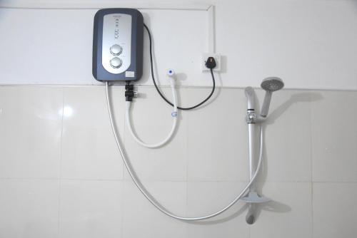 een stethoscoop aangesloten op een douche in de badkamer bij S P City Resort in Anuradhapura