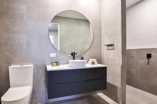 a bathroom with a sink and a mirror at Indulge Apartments - City View Penthouses in Mildura