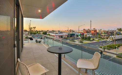 einen Balkon mit einem Tisch und Stühlen sowie Stadtblick in der Unterkunft Indulge Apartments - City View Penthouses in Mildura