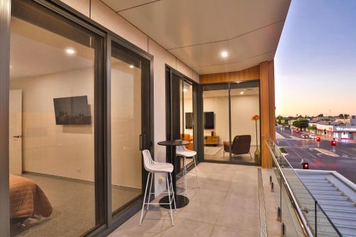 a bedroom with a balcony with a view of a street at Indulge Apartments - City View Penthouses in Mildura