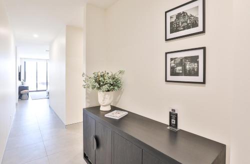 a vase of flowers on top of a cabinet in a room at Indulge Apartments - City View Penthouses in Mildura