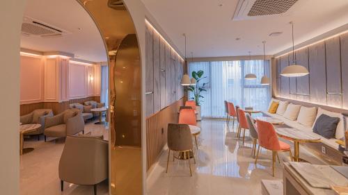 a lobby with tables and chairs in a building at Yeongdo Grandbern Hotel in Busan