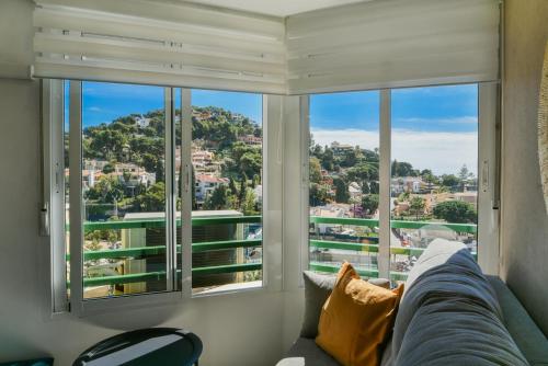 uma sala de estar com um sofá em frente a uma janela em Apartamento a un paso del mar em Málaga