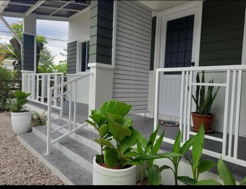 Bann Kam B&B في مينْغكرابي: منزل به نباتات على الشرفة الأمامية