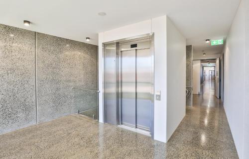 a hallway with a glass door in a building at Indulge Apartments - City View Penthouses in Mildura