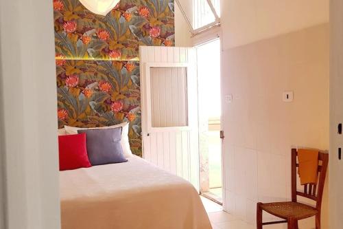 a bedroom with a bed and a floral wallpaper at Vita in Catania