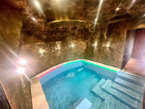 a swimming pool in a cave with lights in it at Al Hamra Mountain View in Al Ḩamrāʼ