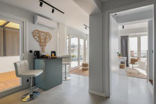 a kitchen and living room with a counter and a chair at Port de L'eau Roof Garden in Thessaloniki