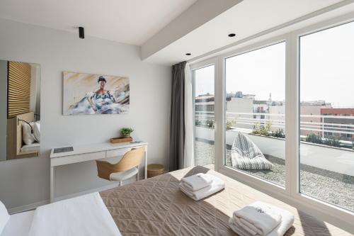 a bedroom with a bed and a large window at Port de L'eau Roof Garden in Thessaloniki