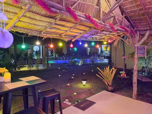 a patio with tables and chairs in a building at Residence M Thailand, Resort, Mae Ramphueng Beach, Ban Phe, Rayong, Residence M Thailand in Ban Chamrung