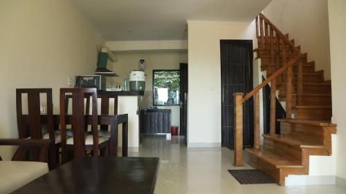 uma cozinha e sala de estar com uma escada de madeira em Just Naturals Wellness Resort Nainital em Bhowāli
