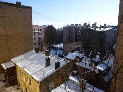 a building with snow on the roof in a city at RigaCenter apartment in Riga
