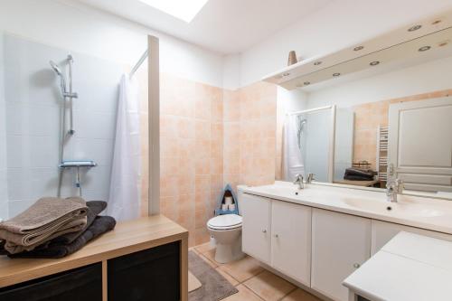 een badkamer met een wastafel, een toilet en een spiegel bij Le Saint-Clémentois - Maison pour 6 in Saint-Clément