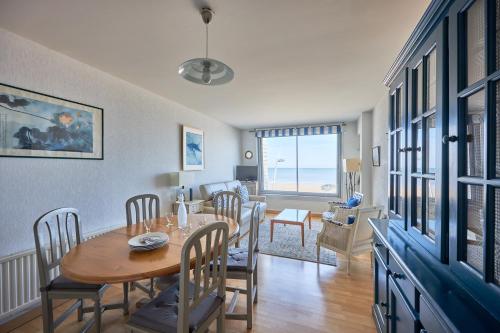 une salle à manger et un salon avec une table et des chaises dans l'établissement Duplex Etoile de mer- T4 Vue mer, à Courseulles-sur-Mer