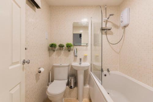 a bathroom with a toilet and a sink and a shower at Surrey Stays - 2 Bedroom House, RH1, Contractors Welcome, Sleeps 5 max, 2 Parking Spaces, Near Town Centre, Train Station and Gatwick Airport in Redhill