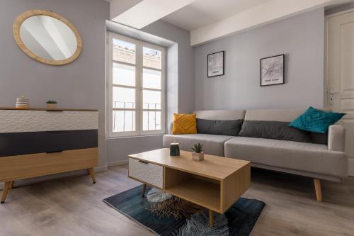 uma sala de estar com um sofá e uma mesa em La Tour - Appt climatisé pour 2 em Aubenas