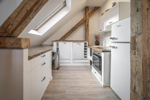 a kitchen with white appliances and wooden ceilings at Luxurious apartment in the heart of Poprad in Poprad