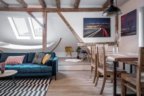 a living room with a blue couch and a table at Luxurious apartment in the heart of Poprad in Poprad