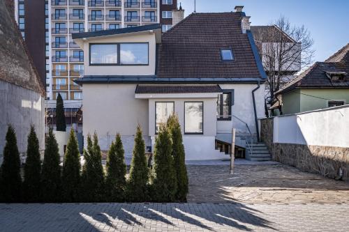 a white house with a black roof at Luxurious apartment in the heart of Poprad in Poprad