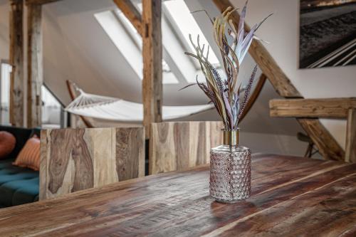 a vase sitting on top of a wooden table at Luxurious apartment in the heart of Poprad in Poprad