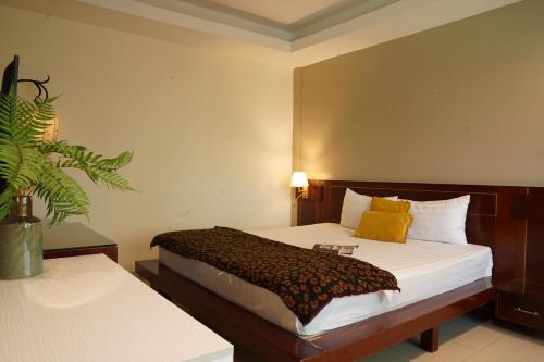 une chambre d'hôtel avec un lit et une plante dans l'établissement Trang An Hotel - 5 minutes Landmark 81, à Hô-Chi-Minh-Ville