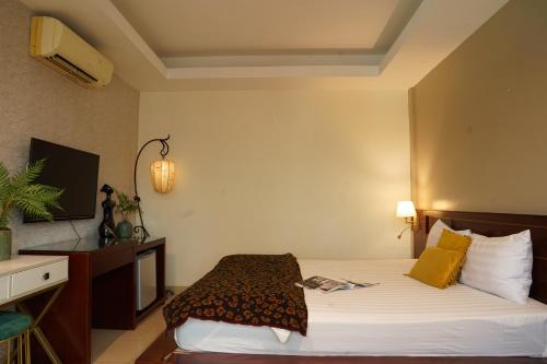 Cette chambre comprend un lit et une télévision. dans l'établissement Trang An Hotel - 5 minutes Landmark 81, à Hô-Chi-Minh-Ville