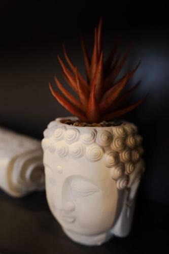 a white vase with a potted plant in it at Spacious Deluxe Seaside Escape in St Paul's Bay