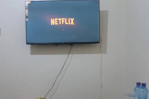 a television with the netflix sign on a wall at LaMeg Homestay in Nairobi