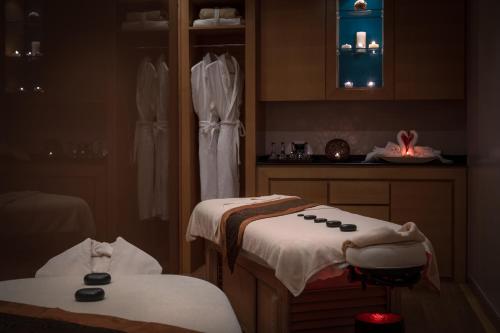 a massage room with two beds in a room with lights at Park Rotana Abu Dhabi in Abu Dhabi
