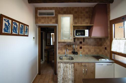 a kitchen with a sink and a microwave at Complejo Rural El Recuerdo in La Pesga