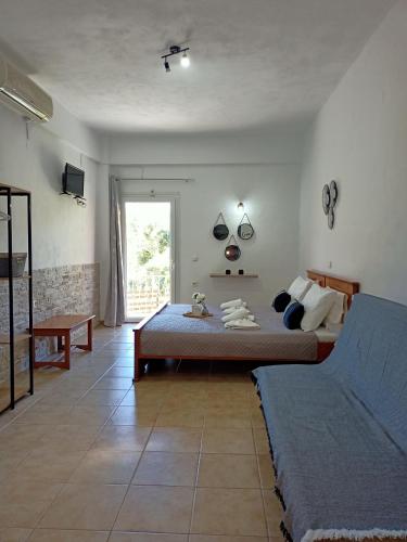 a bedroom with a bed and a couch and a window at DANDOLOS STUDIOS in Parga
