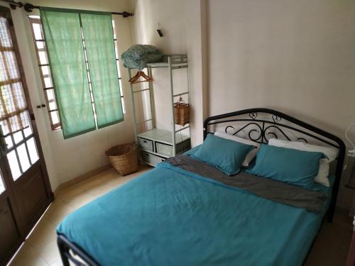 um quarto com uma cama com lençóis azuis e duas janelas em Entire small house mins to everywhere! em Cidade de Ho Chi Minh