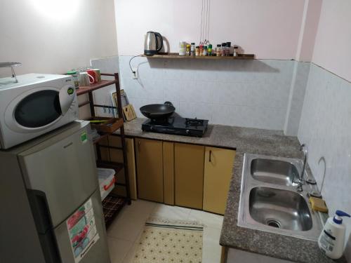 uma pequena cozinha com um lavatório e um micro-ondas em Entire small house mins to everywhere! em Cidade de Ho Chi Minh