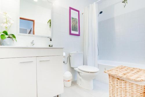 a white bathroom with a toilet and a sink at Apartamento Es Celler in Alcudia