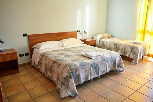 a bedroom with two beds and a tiled floor at Al Casale B&B in Cherasco
