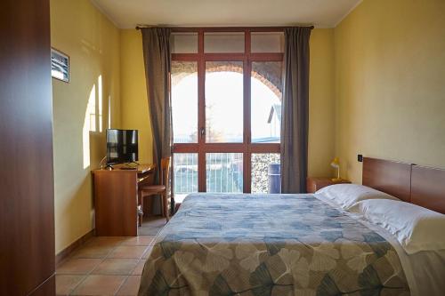 a bedroom with a large bed and a window at Al Casale B&B in Cherasco