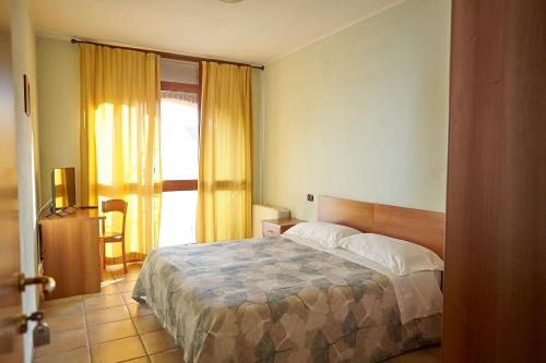 a hotel room with a bed and a window at Al Casale B&B in Cherasco