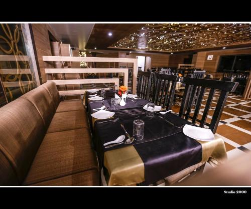 胡布利的住宿－Hotel Trupti International HUBLI，餐厅的一张桌子,上面有黑色桌布