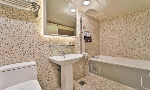 uma casa de banho com um lavatório, um WC e uma banheira em Daegu February Hotel DongdaeguStation em Daegu