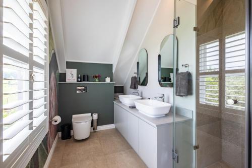 a bathroom with two sinks and two mirrors at Dornoch on Gowrie Farm, Nottingham Road in Nottingham Road