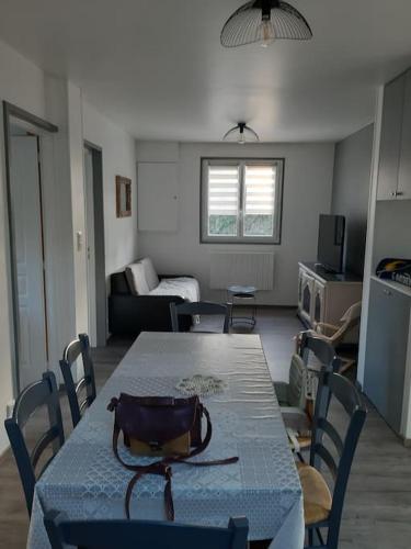 une table et des chaises dans un salon dans l'établissement L'OASIS, à Merville-Franceville-Plage
