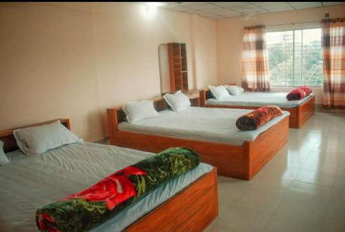 1 dormitorio con 2 camas y 2 almohadas en Hotel Square Park, en Rāngāmāti