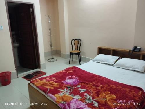 1 dormitorio con 1 cama y 1 silla en Hotel Square Park, en Rāngāmāti