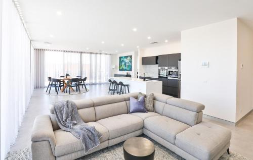 a living room with a couch and a kitchen at Indulge Apartments - City View Penthouses in Mildura